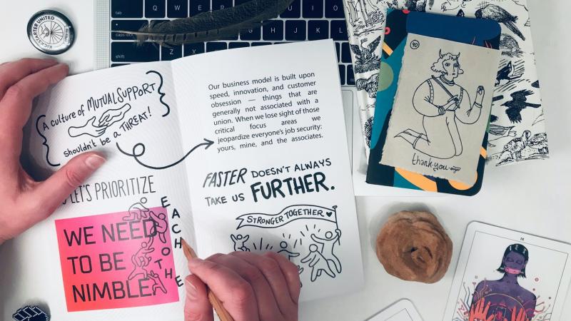 Hands holding open the Solidarity Onboarding zine.